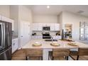 Bright kitchen features a large island, white cabinetry, stainless steel appliances, and modern decor at 1010 Foreshore Ln, Haines City, FL 33844