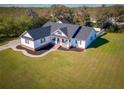 Inviting single-Gathering home featuring a classic white exterior, dark shutters, a welcoming porch, and a spacious lawn at 5118 Norriswood Dr, Mulberry, FL 33860