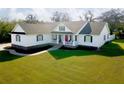 Inviting single-Gathering home featuring a classic white exterior, dark shutters, a welcoming porch, and lush green lawn at 5118 Norriswood Dr, Mulberry, FL 33860