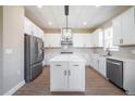 Bright kitchen with white cabinets, stainless steel appliances, and an island with white countertop at 7721 Somersworth Dr, Kissimmee, FL 34747