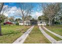 Charming single-story home with a well-maintained lawn and mature trees at 1625 Crystal E Ct, Lakeland, FL 33801