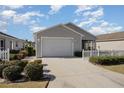 Single-story home with a well-manicured lawn and white picket fence offers great curb appeal at 1654 Indigo Ave, The Villages, FL 32162