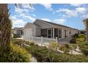 Exterior shot shows the home's screened in patio and well manicured landscaping on a sunny day at 1654 Indigo Ave, The Villages, FL 32162