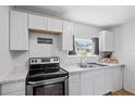 Bright kitchen featuring white cabinets, stainless steel appliances, and a window at 828 W 13Th St, Lakeland, FL 33805