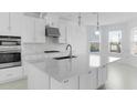 Modern kitchen features an island, stainless steel appliances, pendant lighting, and ample natural light at 5224 Stone Ridge Pl, St Cloud, FL 34771