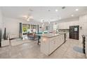 Open-concept living room showcasing tiled floors, a spacious kitchen island, and abundant natural light at 4763 Riverwalk Dr, St Cloud, FL 34771