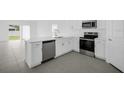 Beautiful kitchen featuring stainless steel appliances, white cabinetry, and gray tile flooring at 1931 Rosewood Cir, Lakeland, FL 33810