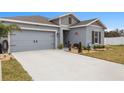 Well-kept single-story house with a spacious driveway, neat landscaping, and an attached two-car garage at 389 Singing Sands Cir, Lake Wales, FL 33859