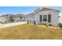 Attractive single-story home showcasing tidy landscaping, a driveway, and a well-maintained exterior at 389 Singing Sands Cir, Lake Wales, FL 33859