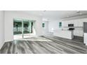 Bright, airy living room with sliding glass doors and modern gray wood flooring at 260 Woodsage Pl, Lake Alfred, FL 33850