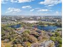 Aerial view of multi-unit dwellings near a lake, retail shopping, and neighborhood at 8825 Latrec Ave # 6308, Orlando, FL 32819