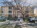 Exterior view of a multi-unit dwelling with some mature landscaping, sidewalk, and assigned parking at 8825 Latrec Ave # 6308, Orlando, FL 32819