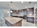Spacious kitchen featuring dark wood cabinets, stainless steel appliances, and a mosaic backsplash at 139 Sunfish Dr, Winter Haven, FL 33881