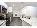 Kitchen with stainless steel appliances, granite counters, and grey wood-look flooring at 13434 Leaping Water Way, Astatula, FL 34705