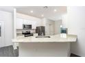 Well-lit kitchen featuring stainless steel appliances and a granite countertop bar at 13434 Leaping Water Way, Astatula, FL 34705