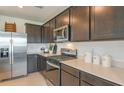 Modern kitchen featuring stainless steel appliances, dark wood cabinets and light countertops at 276 Woodsage Pl, Lake Alfred, FL 33850