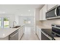 Bright kitchen boasts stainless steel appliances, white cabinets, and an island overlooking the backyard and dining area at 276 Woodsage Pl, Lake Alfred, FL 33850