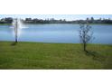 Scenic lake view with a fountain, surrounded by lush greenery and peaceful ambiance at 1371 Pompay Dr, Davenport, FL 33896