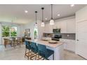 Bright kitchen featuring stainless steel appliances, a large island with counter seating, and elegant pendant lighting at 6781 Sw 90Th Loop, Ocala, FL 34476