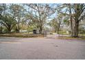 Street view of a quaint single-story home, mature trees, and a fenced front yard at 820 N Carroll Rd, Lakeland, FL 33801