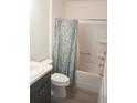 Clean bathroom showcasing a shower-tub combination with a leaf patterned curtain and a modern vanity at 1974 Lockett Ln, The Villages, FL 34762