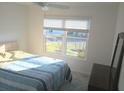 Bright bedroom featuring a ceiling fan, a large window with blinds, and neutral decor at 1974 Lockett Ln, The Villages, FL 34762