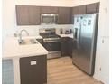 Modern kitchen with stainless steel appliances, dark wood cabinets, and a breakfast bar area at 1974 Lockett Ln, The Villages, FL 34762