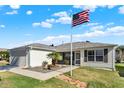 Inviting single-story home with well-kept lawn, stone walkway, and American flag at 2337 St George Ave, The Villages, FL 32162