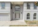 Front entrance with a decorative door, arched windows, and a well-manicured lawn at 6087 Sunset Vista Dr, Lakeland, FL 33812