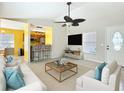 Bright living room featuring tile flooring, large windows, a ceiling fan, and an open view to the kitchen at 703 New York Ave, South Daytona, FL 32119