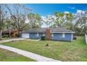 Attractive one-story home featuring blue siding, a brick chimney, and a green front lawn at 3322 Heather Glynn Dr, Mulberry, FL 33860