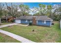 Attractive one-story home featuring blue siding, a brick chimney, and a green front lawn at 3322 Heather Glynn Dr, Mulberry, FL 33860