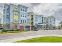 Well-maintained condo building with colorful exterior, manicured landscaping, and convenient covered parking for residents and guests at 7517 Laureate Blvd # 4303, Orlando, FL 32827