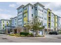 Well-maintained condo building with colorful exterior, manicured landscaping, and convenient covered parking for residents and guests at 7517 Laureate Blvd # 4303, Orlando, FL 32827