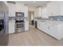 Bright kitchen with stainless steel appliances, white cabinets, blue backsplash, and lots of natural light at 7517 Laureate Blvd # 4303, Orlando, FL 32827
