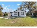 Quaint single-story home with fresh exterior paint, dark trim and a well-maintained lawn at 1104 W 9Th St, Lakeland, FL 33805