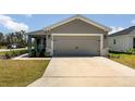 Attached two-car garage with concrete driveway and stone accents at 1047 Aruba Ave, Mulberry, FL 33860