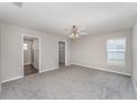 Spacious primary bedroom with neutral carpet, ceiling fan, and ensuite bathroom at 1047 Aruba Ave, Mulberry, FL 33860