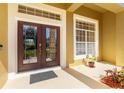 Elegant double front doors framed by decorative pillars and manicured landscaping at the entrance at 11321 Ledgement Ln, Windermere, FL 34786