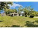 Quaint single-story home featuring a screened porch and large lawn, with a detached garage at 14285 Oconner Rd, Kathleen, FL 33849