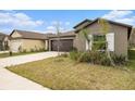 View of a single-story home with a well-kept lawn and attached two-car garage at 1700 Red Loop, Lakeland, FL 33801