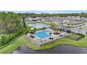 Aerial view of a community pool surrounded by lounge chairs, palm trees and a lake at 1700 Red Loop, Lakeland, FL 33801