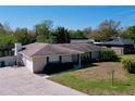 A single-story brick home boasts a neatly landscaped yard and well-maintained grounds beneath a clear blue sky at 1743 Wilshire Ct, Lakeland, FL 33813