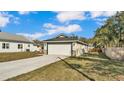 View of the home showcasing the spacious driveway, lawn, and proximity to neighboring houses at 420 Tecumseh N Ave, Fort Meade, FL 33841
