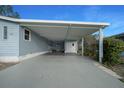 Carport with painted floor and storage that leads to a cozy outdoor seating area at 1717 Lilly Ln, Lady Lake, FL 32159