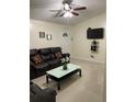 Comfortable living room with tile floors, ceiling fan, and a sleek glass-top coffee table at 5977 Wallace Dr, Orlando, FL 32807