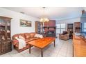 Inviting living room featuring a brick fireplace, hardwood furniture, and neutral decor, creating a cozy atmosphere at 12172 Se 96Th Ter, Belleview, FL 34420