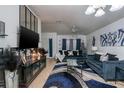 Stylishly decorated living room with modern furniture, a large TV, and a unique blue and silver color scheme at 4067 Sw 46Th Ter, Ocala, FL 34474