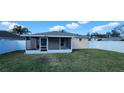 Fenced in backyard featuring a screened in porch and a well maintained lawn at 1404 Country Chase Dr, Lakeland, FL 33810