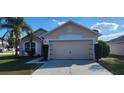 Home with a large two-car garage, neutral paint, and well-kept landscaping at 1404 Country Chase Dr, Lakeland, FL 33810